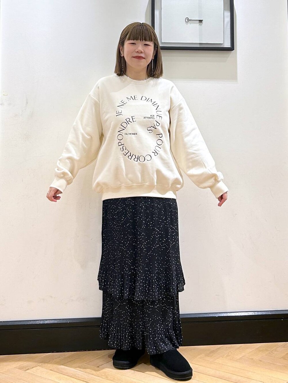 グレー系のスカート、ホワイト系のスウェット、ブラック系のスリッポンを着用したレディースの秋コーディネートの5枚目の写真