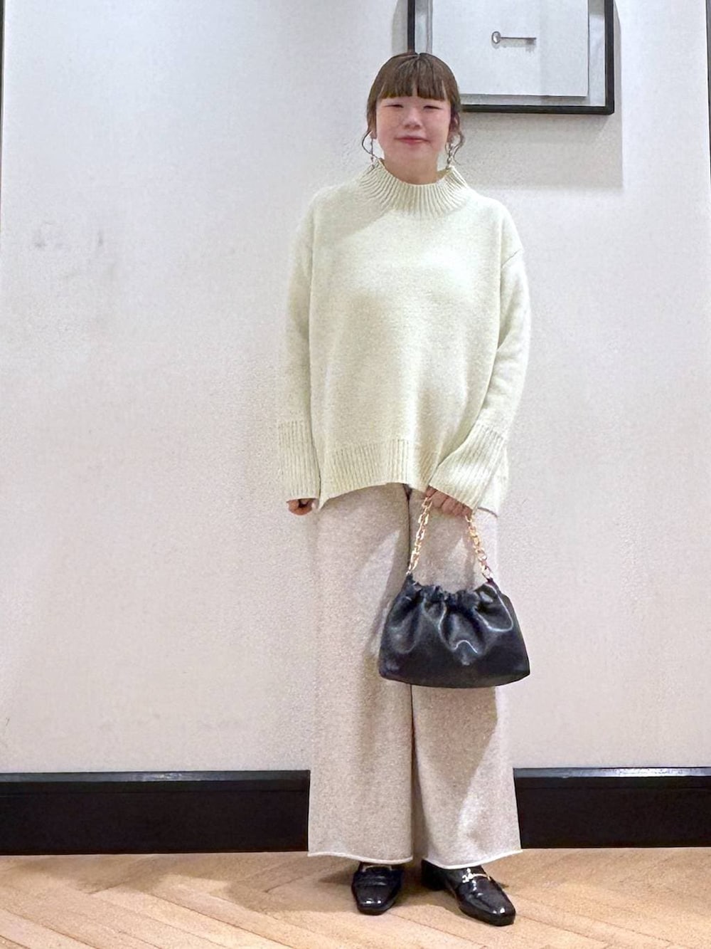 ブラック系のローファー、イエロー系のニット/セーター、ブラック系のショルダーバッグを着用したレディースの冬コーディネートの4枚目の写真