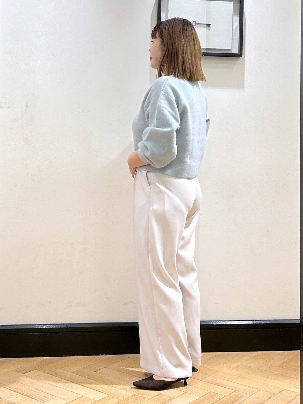 グリーン系のカーディガン/ボレロ、ホワイト系のスラックス、ブラウン系のパンプスを着用したレディースの秋コーディネートの5枚目の写真