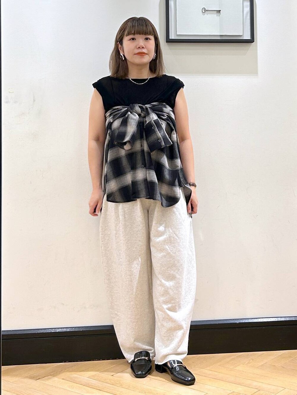 ブラック系のローファー、グレー系のスウェットパンツ、ブラック系のTシャツ/カットソーを着用したレディースの夏コーディネートの4枚目の写真