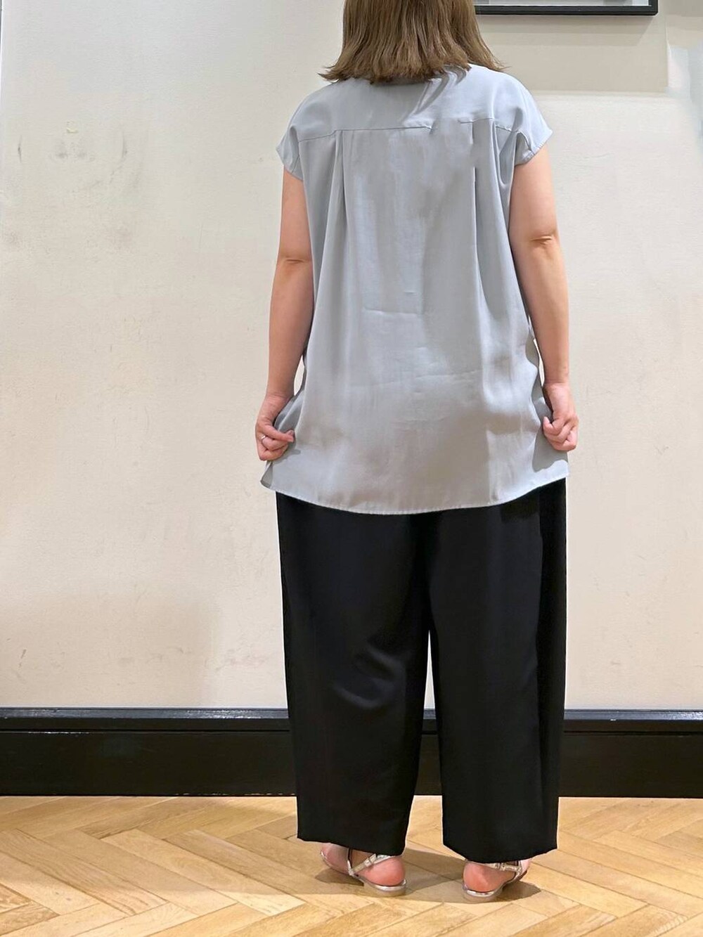 シルバー系のサンダル、ブラック系のスラックス、ブラック系のショルダーバッグを着用したレディースの夏コーディネートの6枚目の写真