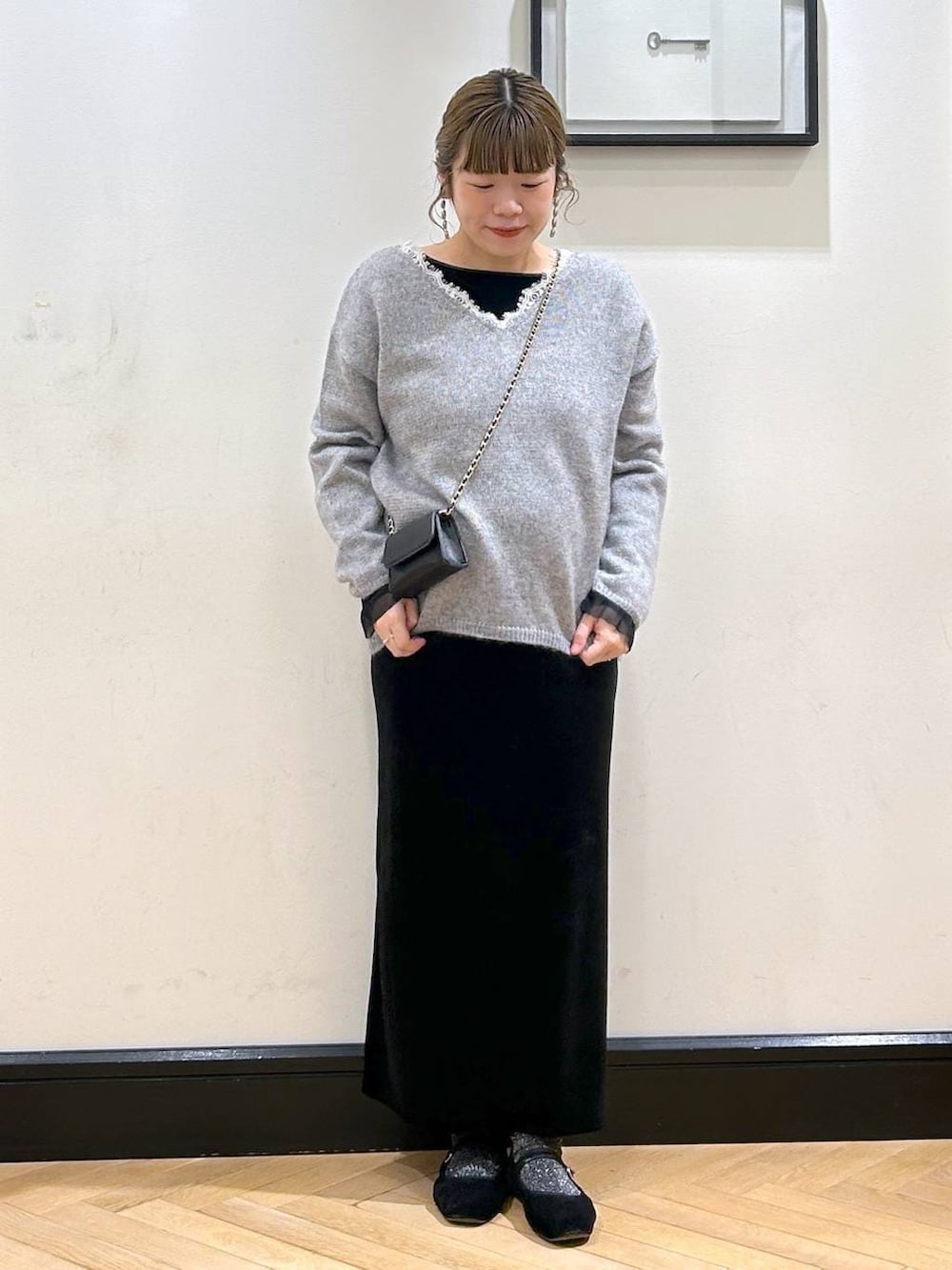 グレー系のニット/セーター、ブラック系のワンピースを着用したレディースの冬コーディネートの2枚目の写真