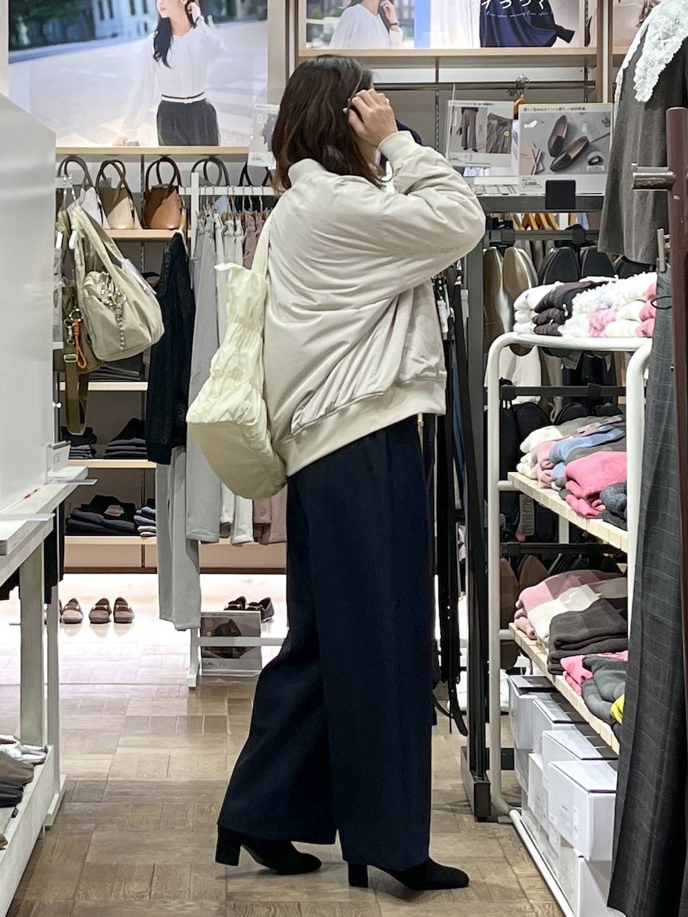 ベージュ系のトートバッグ、ベージュ系のブルゾン、グレー系のTシャツ/カットソーを着用したレディースの秋コーディネートの2枚目の写真