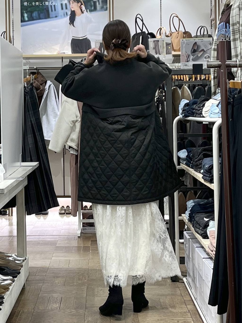 ブラウン系のステンカラーコート、ホワイト系のニット/セーター、ブラック系のショルダーバッグを着用したレディースの秋コーディネートの3枚目の写真