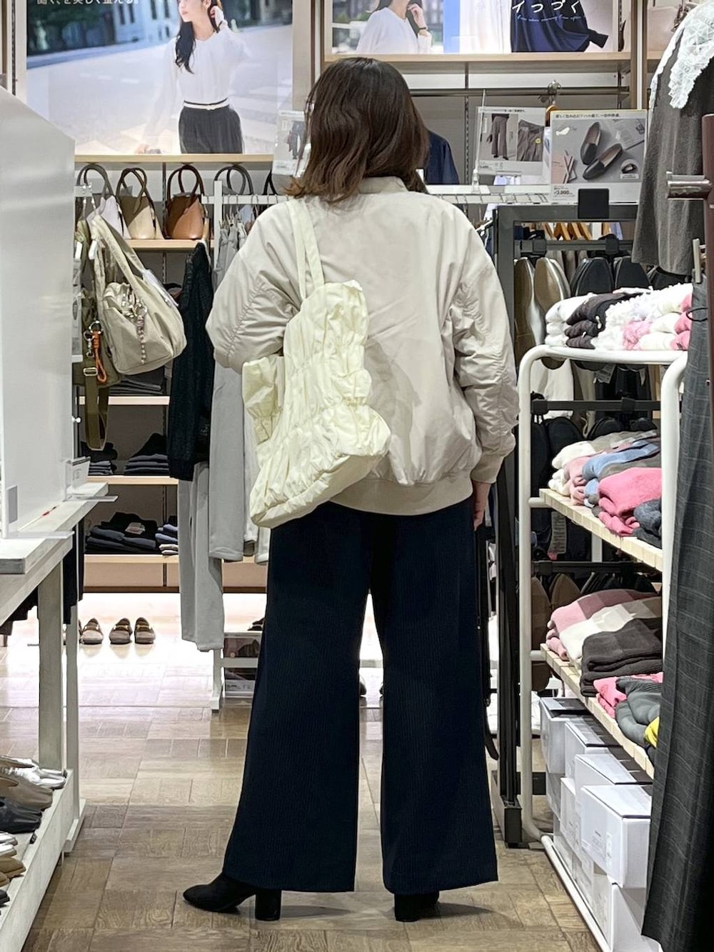 ベージュ系のトートバッグ、ベージュ系のブルゾン、グレー系のTシャツ/カットソーを着用したレディースの秋コーディネートの3枚目の写真