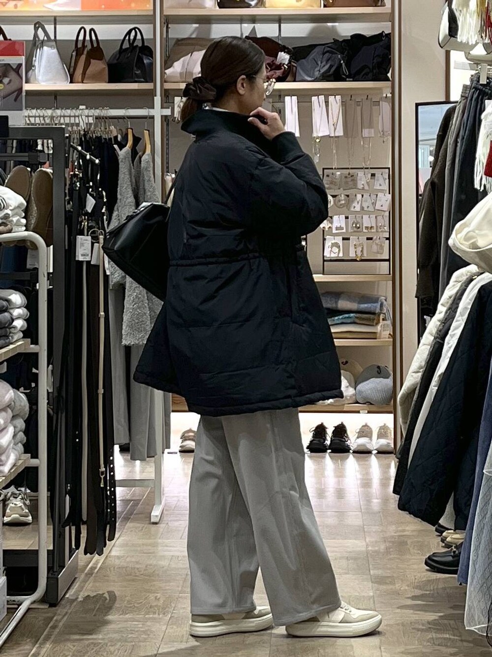 ブラック系のダウンジャケット/コート、ブラック系のボストンバッグ、グレー系のその他パンツを着用したレディースの秋コーディネートの2枚目の写真