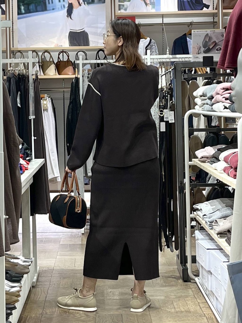 ベージュ系のスニーカー、ブラウン系のワンピース、ブラック系のボストンバッグを着用したレディースの秋コーディネートの3枚目の写真