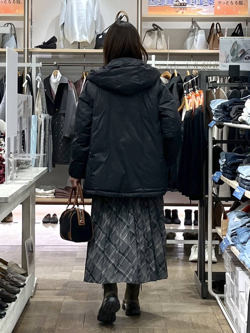 ブラック系のダウンジャケット/コート、ブラウン系のブーツ、ベージュ系のニット/セーターを着用したレディースの冬コーディネートの3枚目の写真