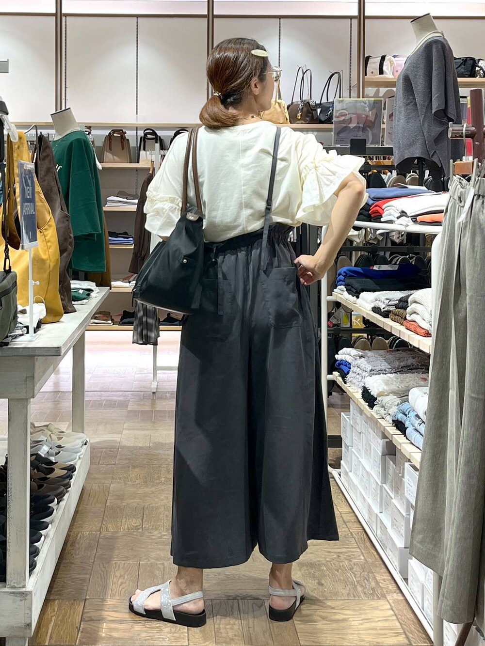 グレー系のサンダル、グレー系のその他パンツ、ブラック系のトートバッグを着用したレディースの秋コーディネートの3枚目の写真