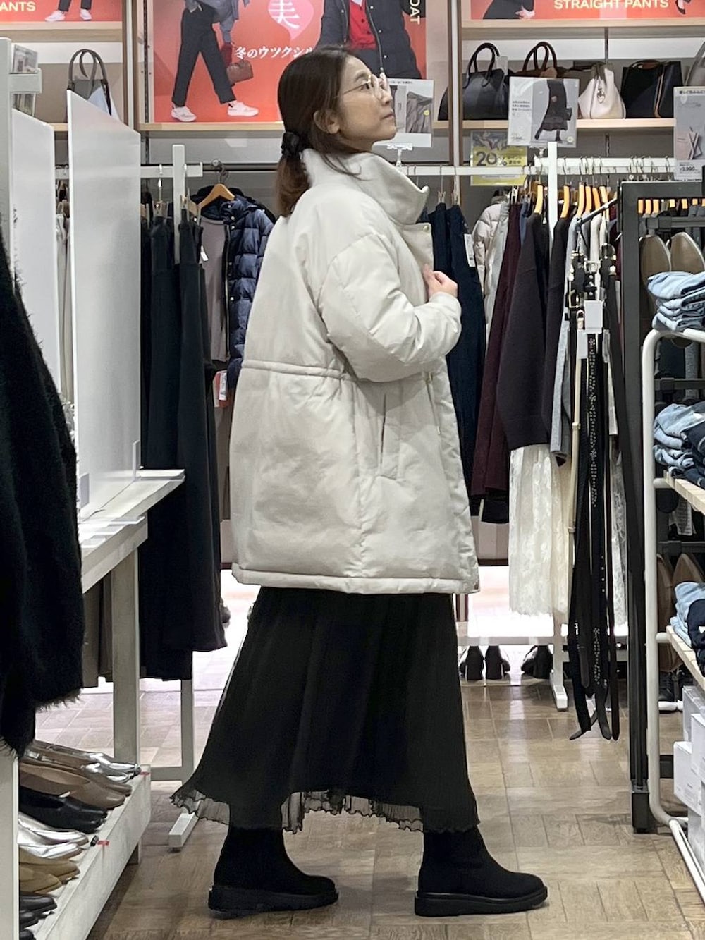 ブラウン系のショルダーバッグ、ベージュ系のダウンジャケット/コート、グレー系のワンピースを着用したレディースの秋コーディネートの2枚目の写真