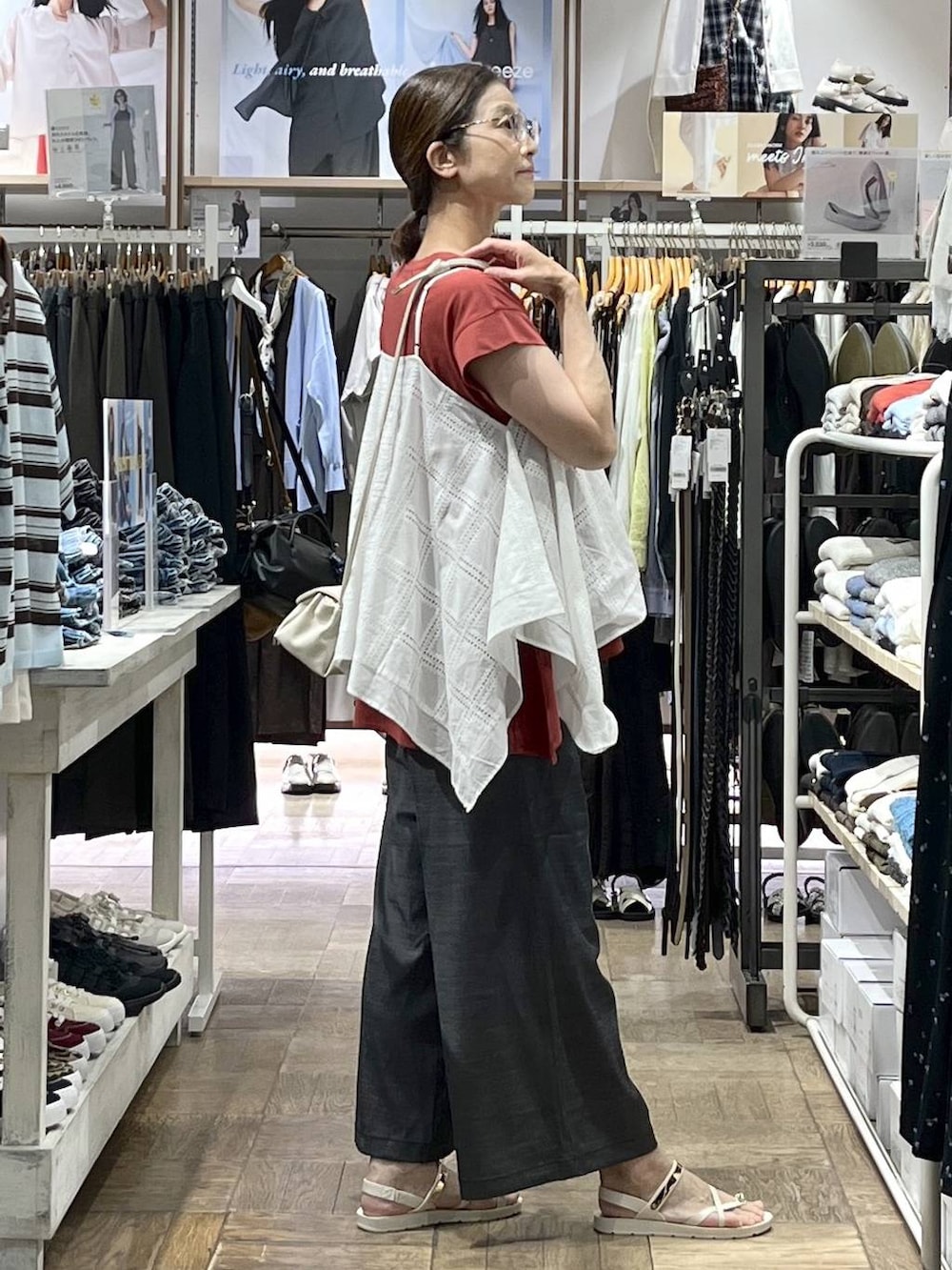ベージュ系のショルダーバッグ、ブラック系のその他パンツ、レッド系のTシャツ/カットソーを着用したレディースの夏コーディネートの2枚目の写真