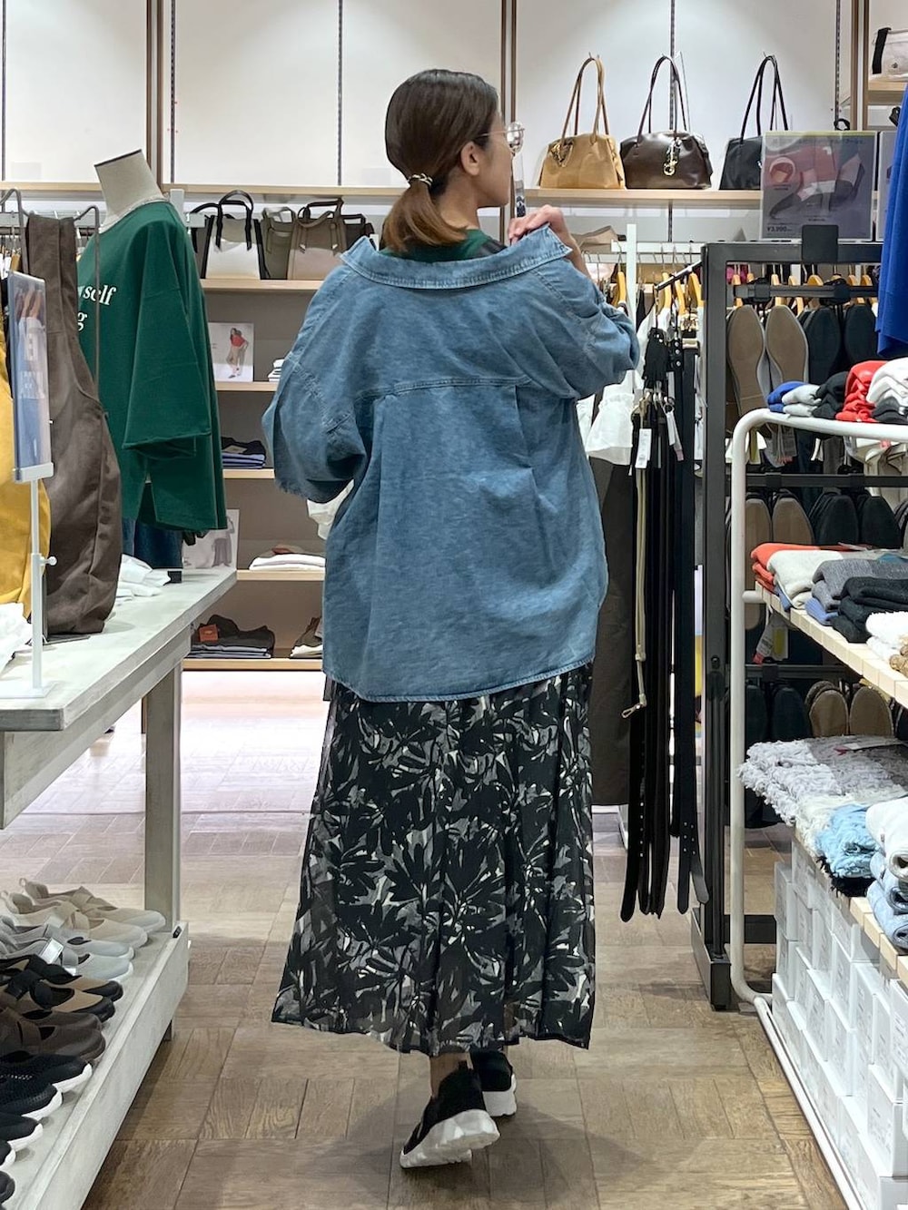 ブラック系のスニーカー、ブルー系のシャツ/ブラウス、ブラック系のスカートを着用したレディースの秋コーディネートの3枚目の写真