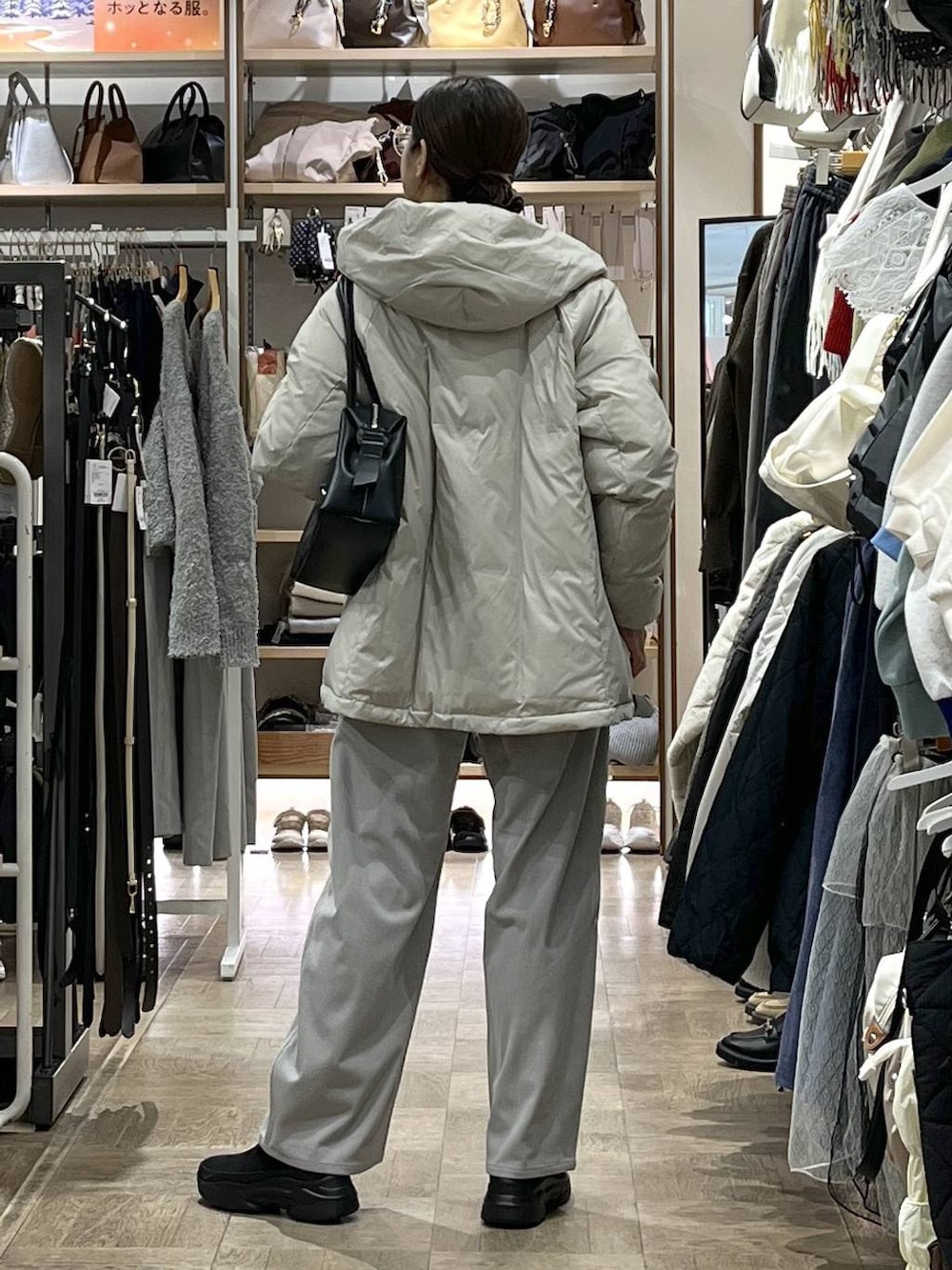 ベージュ系のダウンジャケット/コート、ブラック系のボストンバッグ、グレー系のその他パンツを着用したレディースの冬コーディネートの3枚目の写真