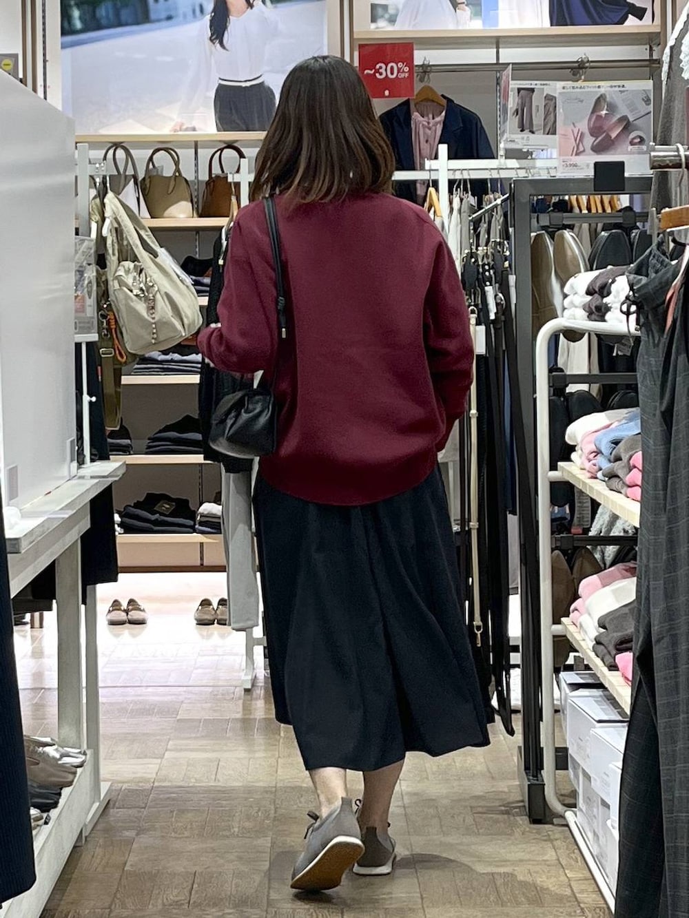 レッド系のスウェット、グレー系のスカート、グレー系のスニーカーを着用したレディースの秋コーディネートの3枚目の写真