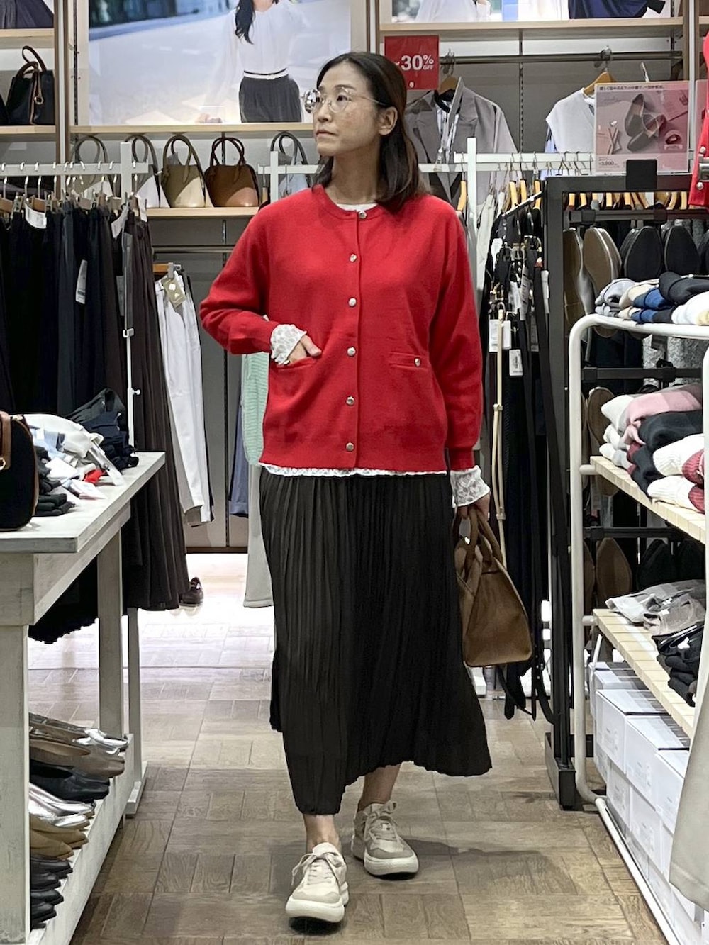 レッド系のカーディガン/ボレロ、ベージュ系のショルダーバッグ、ホワイト系のTシャツ/カットソーを着用したレディースの秋コーディネートの2枚目の写真