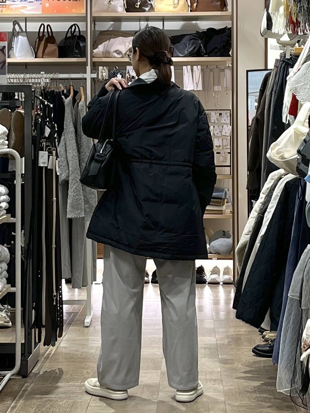 ブラック系のダウンジャケット/コート、ブラック系のボストンバッグ、グレー系のその他パンツを着用したレディースの秋コーディネートの3枚目の写真