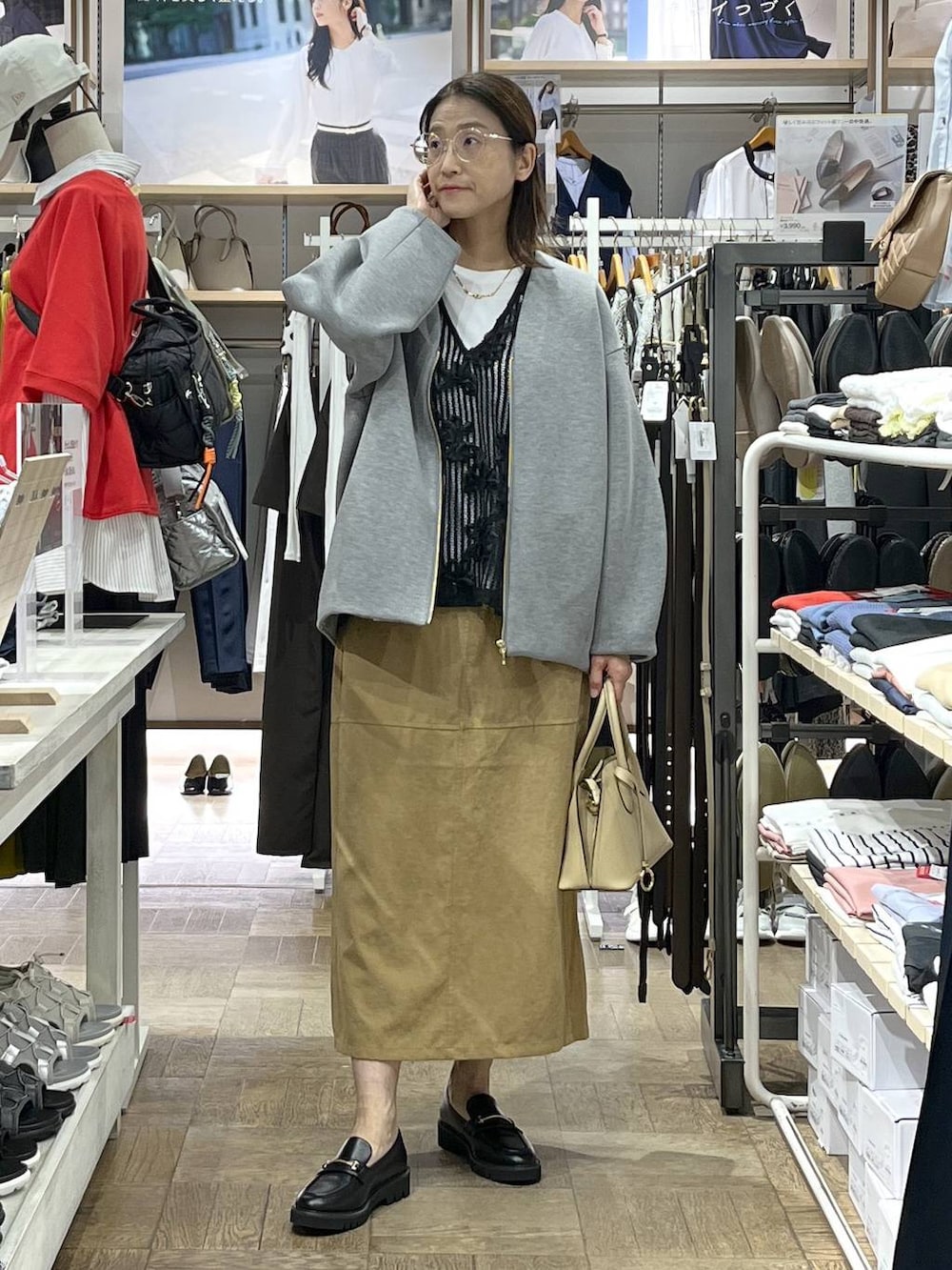 ベージュ系のショルダーバッグ、ブラック系のローファー、グレー系のブルゾンを着用したレディースの秋コーディネートの2枚目の写真