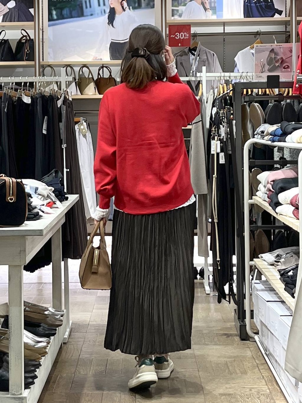 レッド系のカーディガン/ボレロ、ベージュ系のショルダーバッグ、ホワイト系のTシャツ/カットソーを着用したレディースの秋コーディネートの3枚目の写真