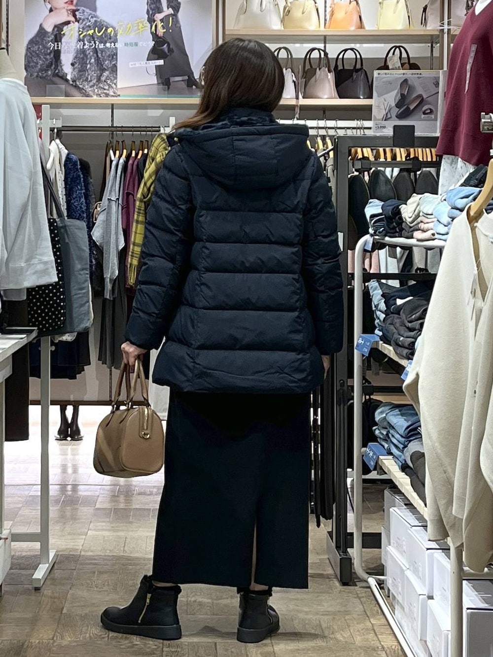 ブルー系のダウンジャケット/コート、ブラック系のカーディガン/ボレロ、ブラック系のスカートを着用したレディースの冬コーディネートの3枚目の写真