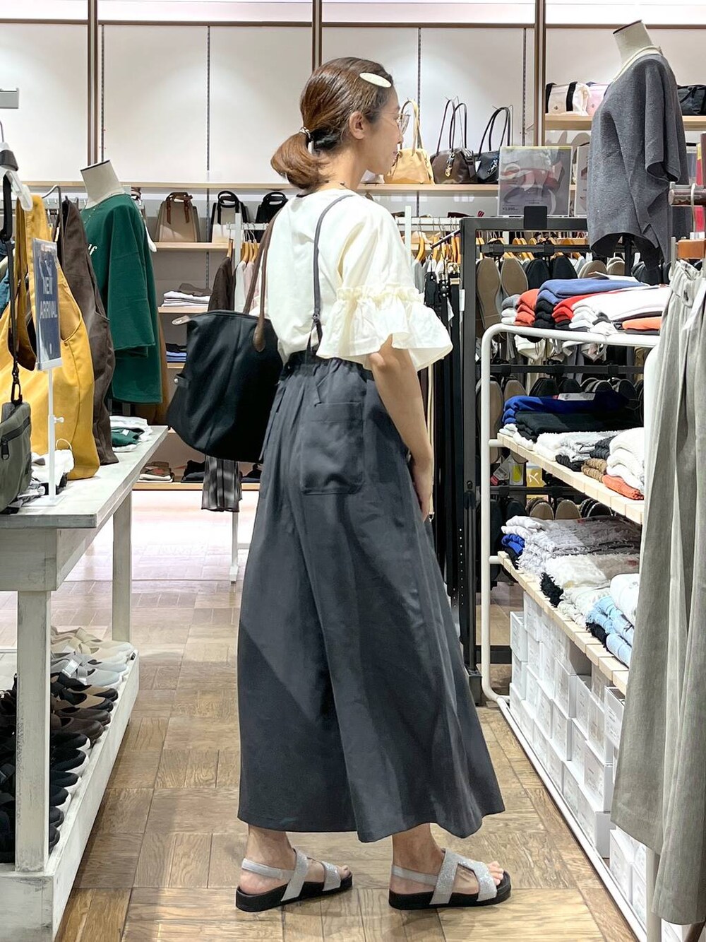 グレー系のサンダル、グレー系のその他パンツ、ブラック系のトートバッグを着用したレディースの秋コーディネートの2枚目の写真