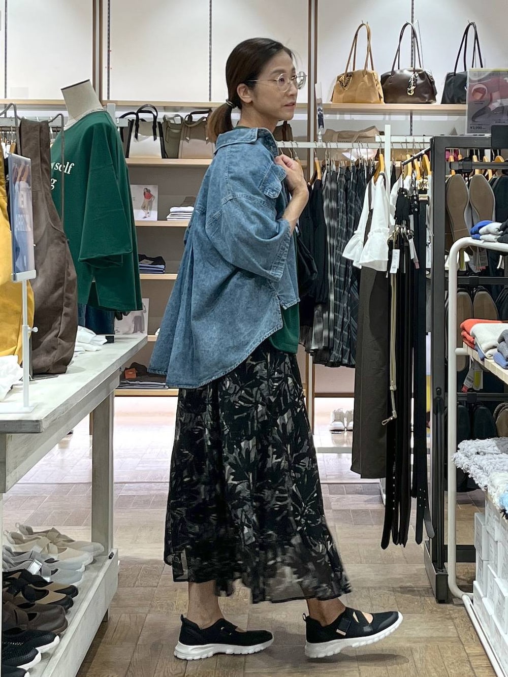 ブラック系のスニーカー、ブルー系のシャツ/ブラウス、ブラック系のスカートを着用したレディースの秋コーディネートの2枚目の写真