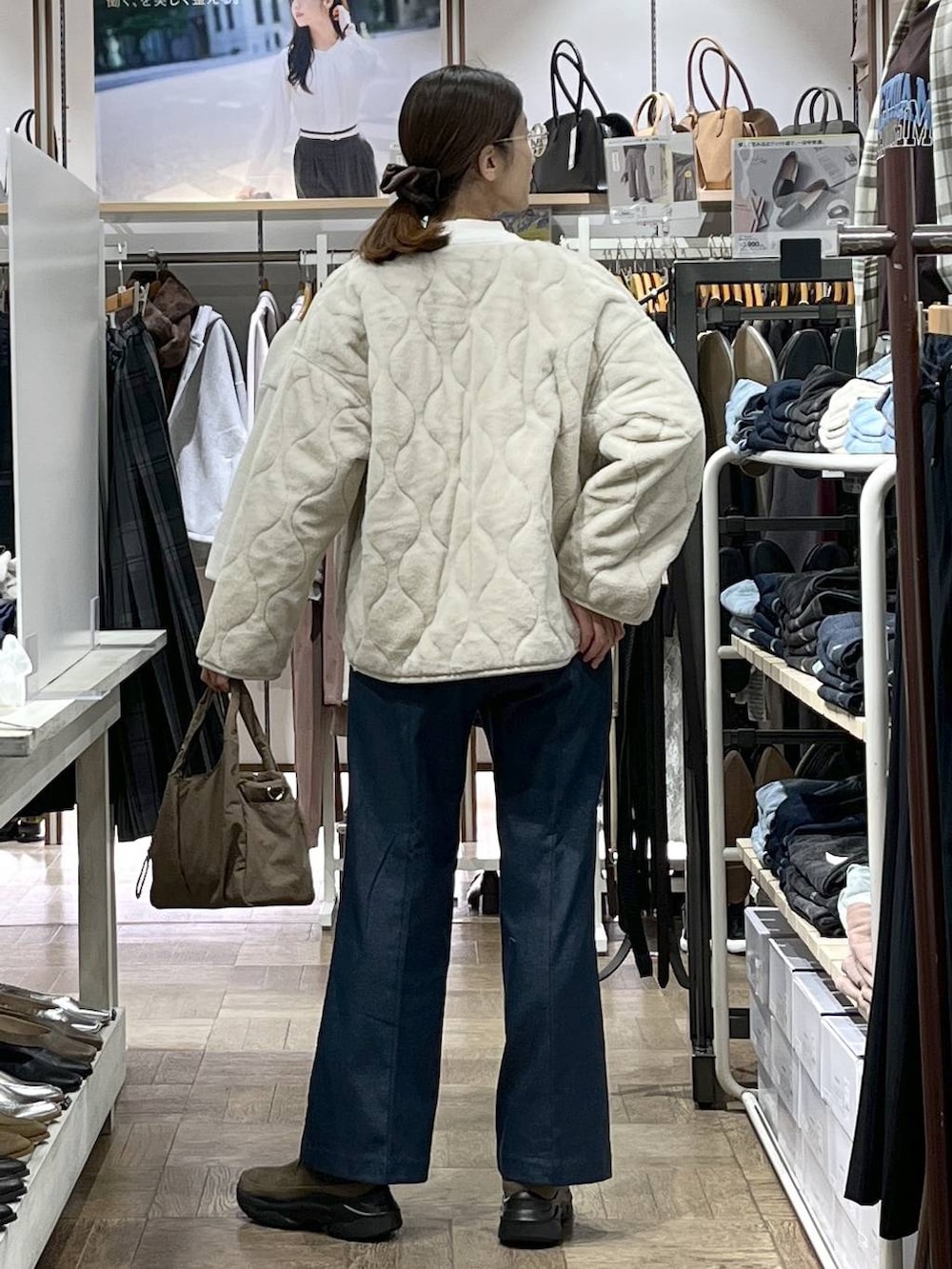ベージュ系のトートバッグ、ベージュ系のブルゾン、ホワイト系のニット/セーターを着用したレディースの秋コーディネートの3枚目の写真
