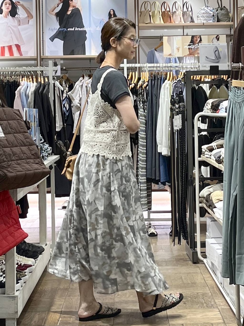 ブラウン系のボストンバッグ、ホワイト系のスカート、ブラック系のサンダルを着用したレディースの夏コーディネートの2枚目の写真