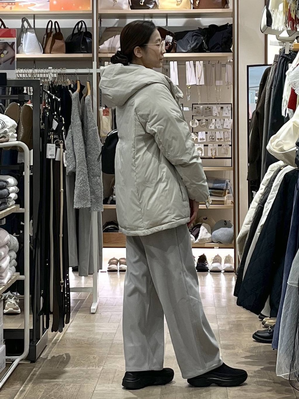 ベージュ系のダウンジャケット/コート、ブラック系のボストンバッグ、グレー系のその他パンツを着用したレディースの冬コーディネートの2枚目の写真