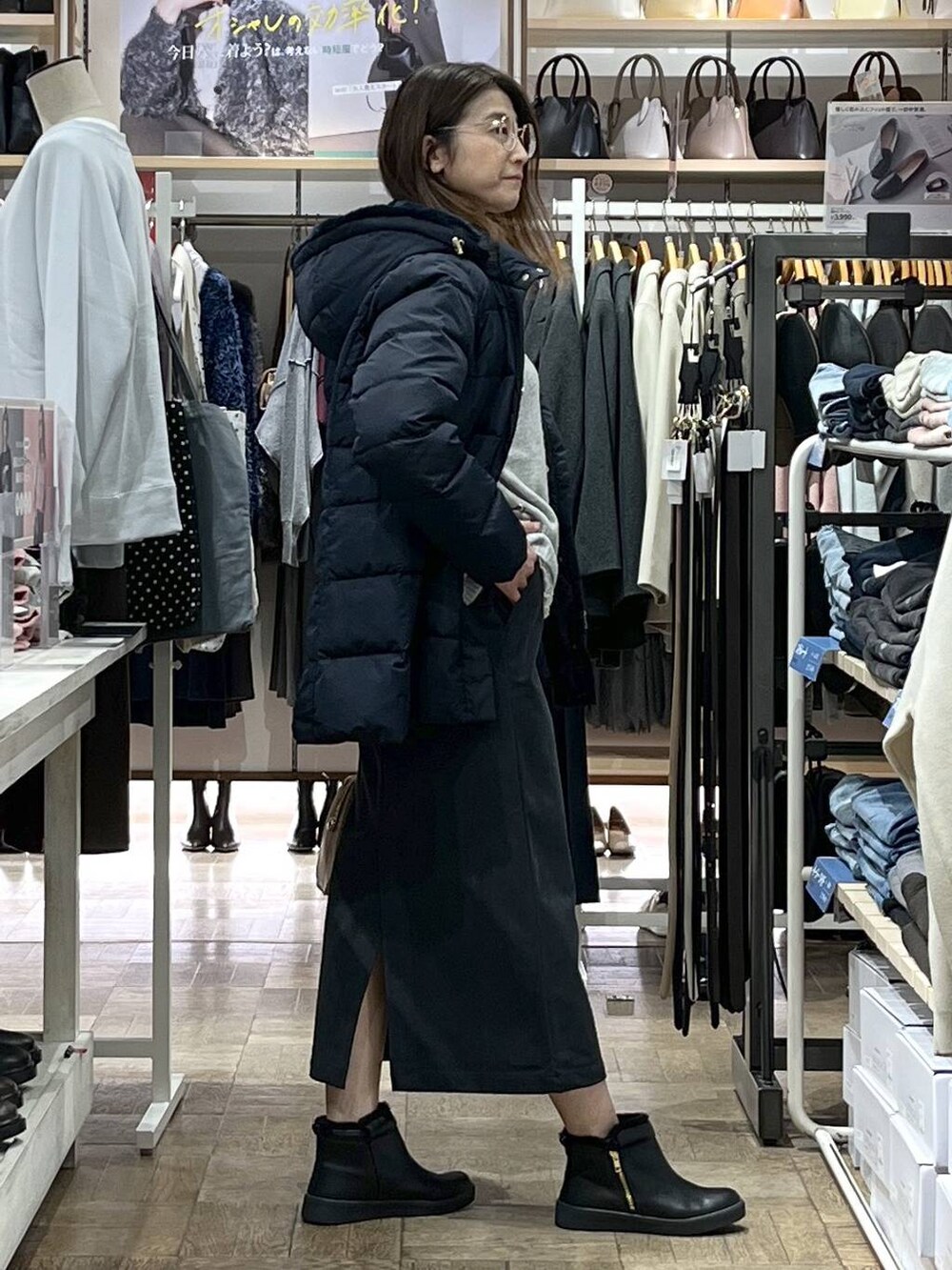 ブルー系のダウンジャケット/コート、グレー系のスカート、シルバー系のニット/セーターを着用したレディースの冬コーディネートの2枚目の写真