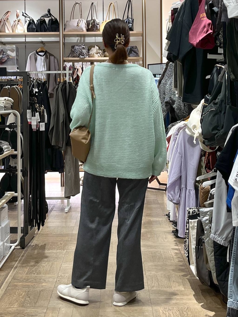 グレー系のその他パンツ、ベージュ系のスニーカー、グリーン系のニット/セーターを着用したレディースの秋コーディネートの3枚目の写真