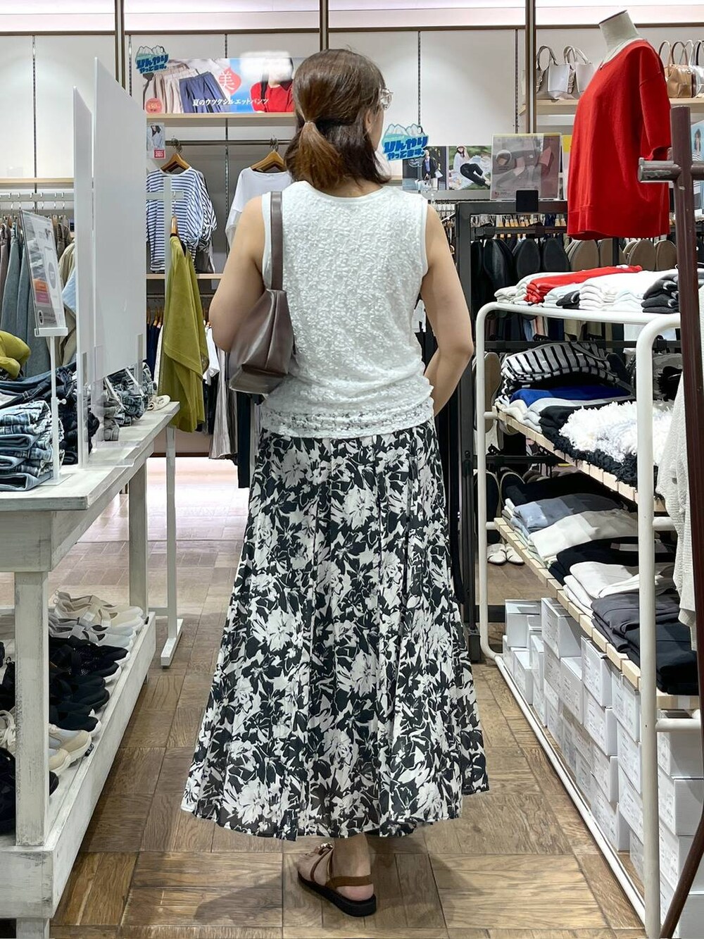 ブラック系のスカート、ブラウン系のショルダーバッグ、ホワイト系のタンクトップを着用したレディースの夏コーディネートの3枚目の写真