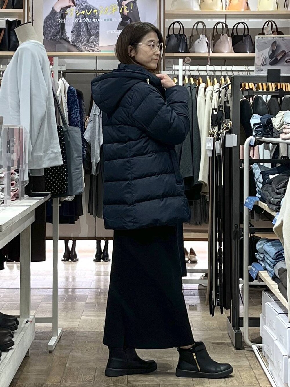 ブルー系のダウンジャケット/コート、ブラック系のカーディガン/ボレロ、ブラック系のスカートを着用したレディースの冬コーディネートの2枚目の写真