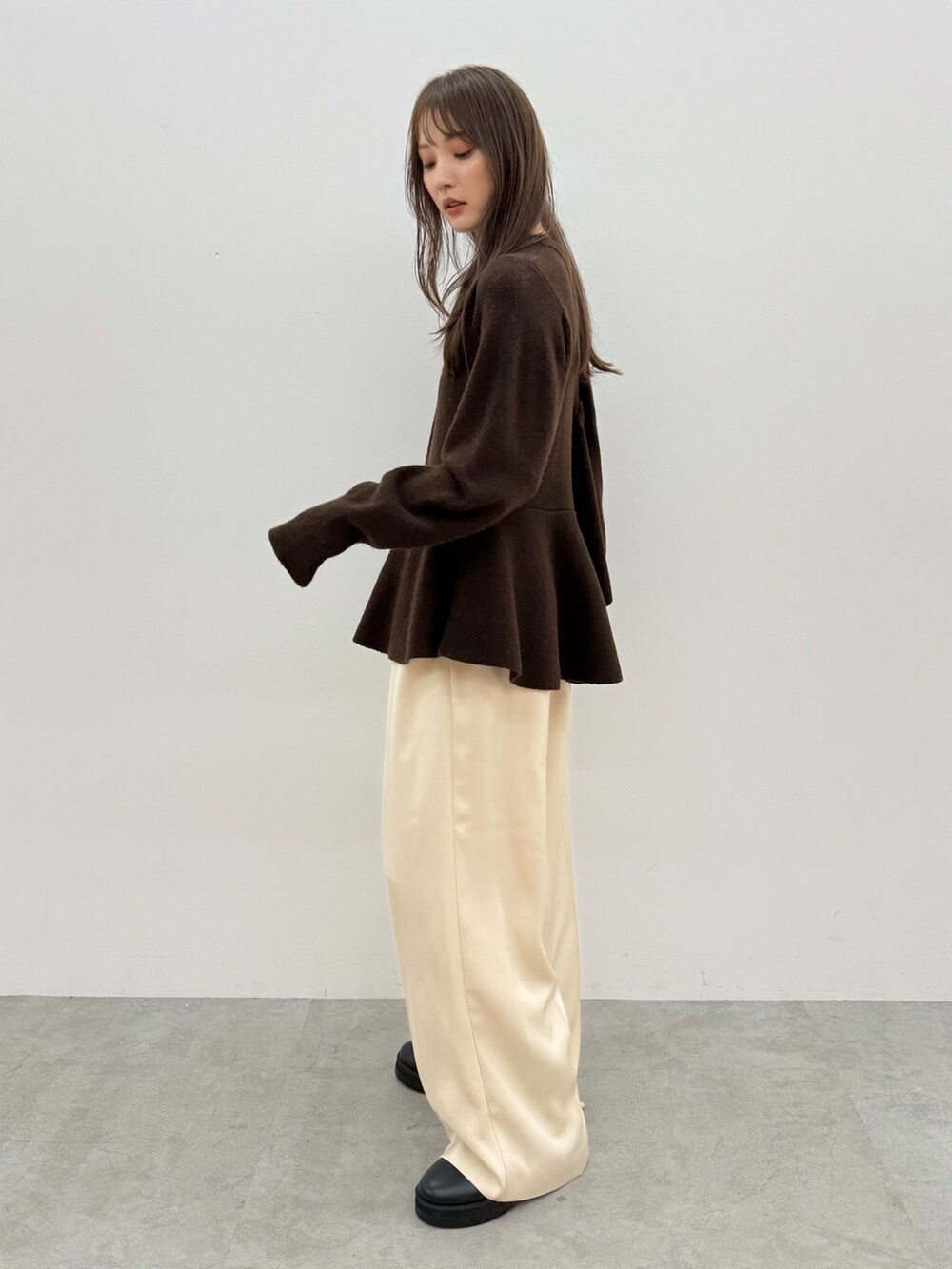 ブラウン系のニット/セーター、ホワイト系のその他パンツを着用したレディースの秋コーディネートの3枚目の写真