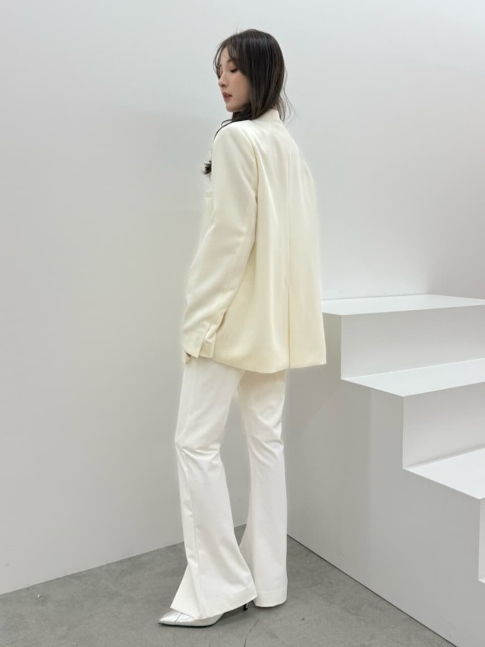 ホワイト系のその他パンツ、ホワイト系のノーカラージャケットを着用したレディースの冬コーディネートの3枚目の写真