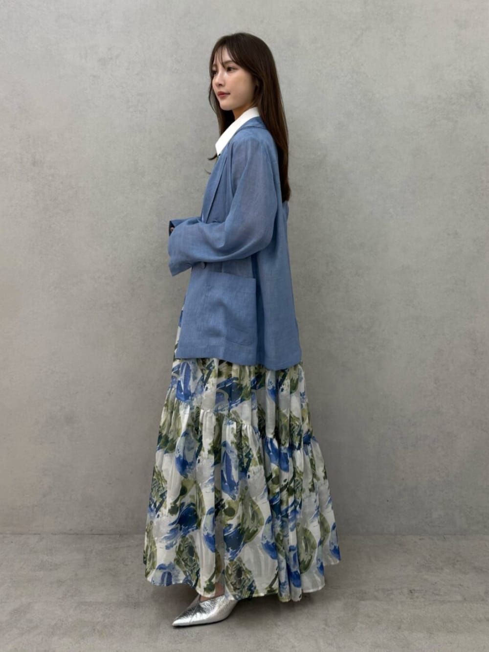 シルバー系のパンプス、ブルー系のテーラードジャケット、ブルー系のワンピースを着用したレディースの春コーディネートの3枚目の写真