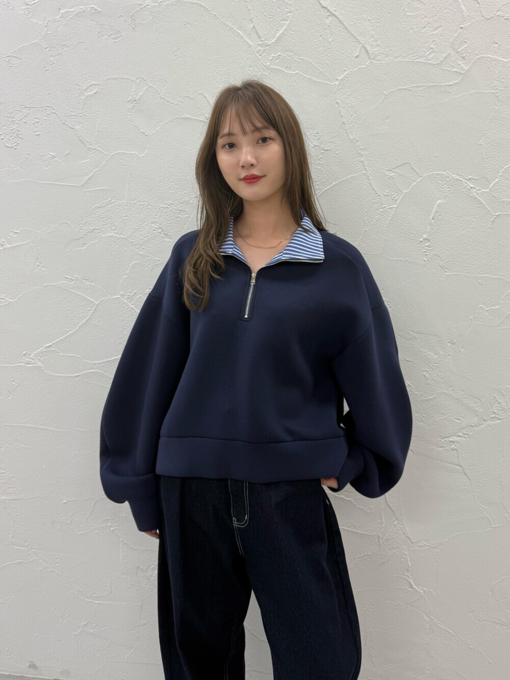 ブルー系のTシャツ/カットソー、シルバー系のパンプス、ブルー系のデニムパンツを着用したレディースの秋コーディネートの5枚目の写真