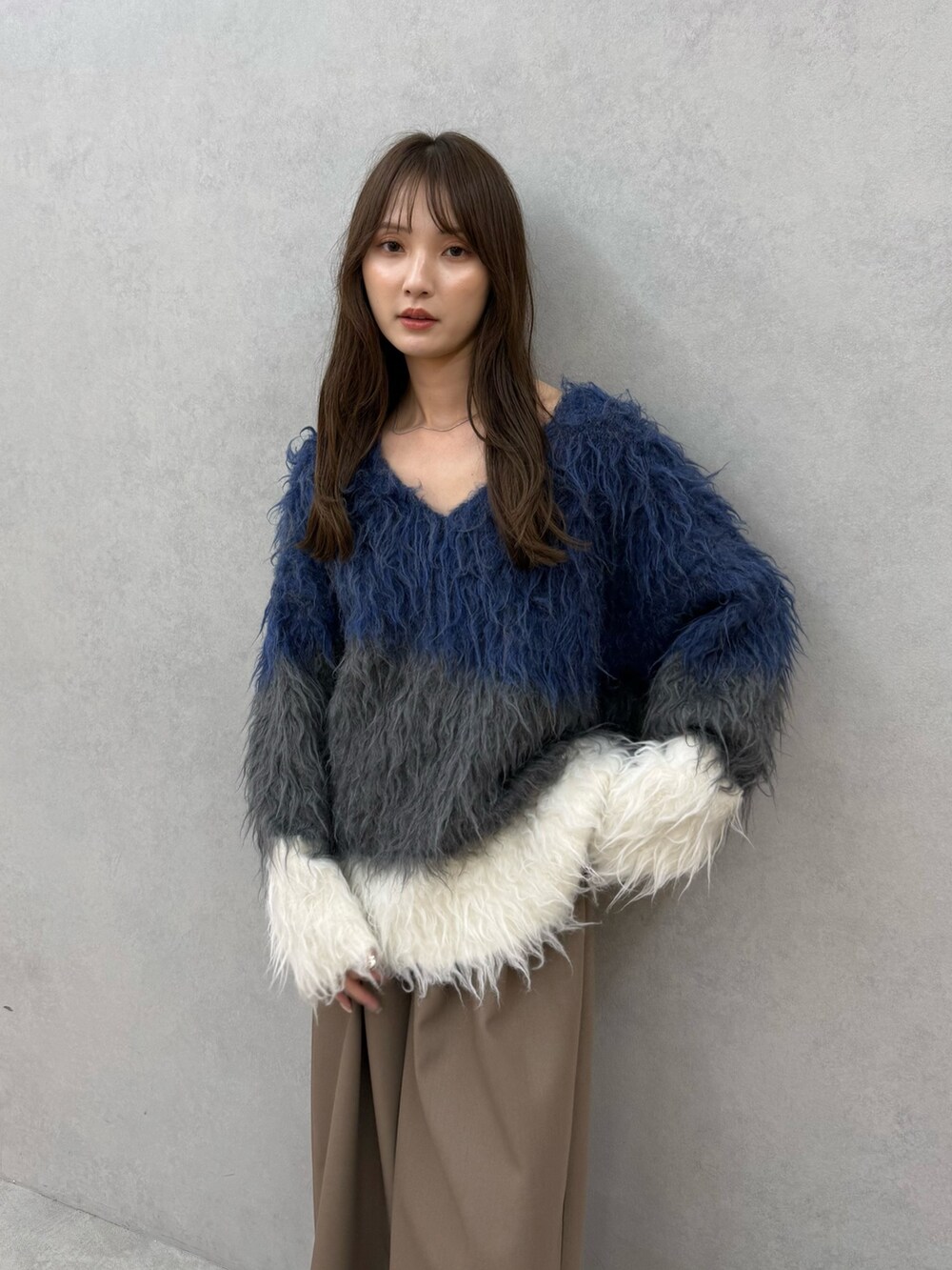 ブルー系のニット/セーター、ブラウン系のその他パンツを着用したレディースの秋コーディネートの6枚目の写真