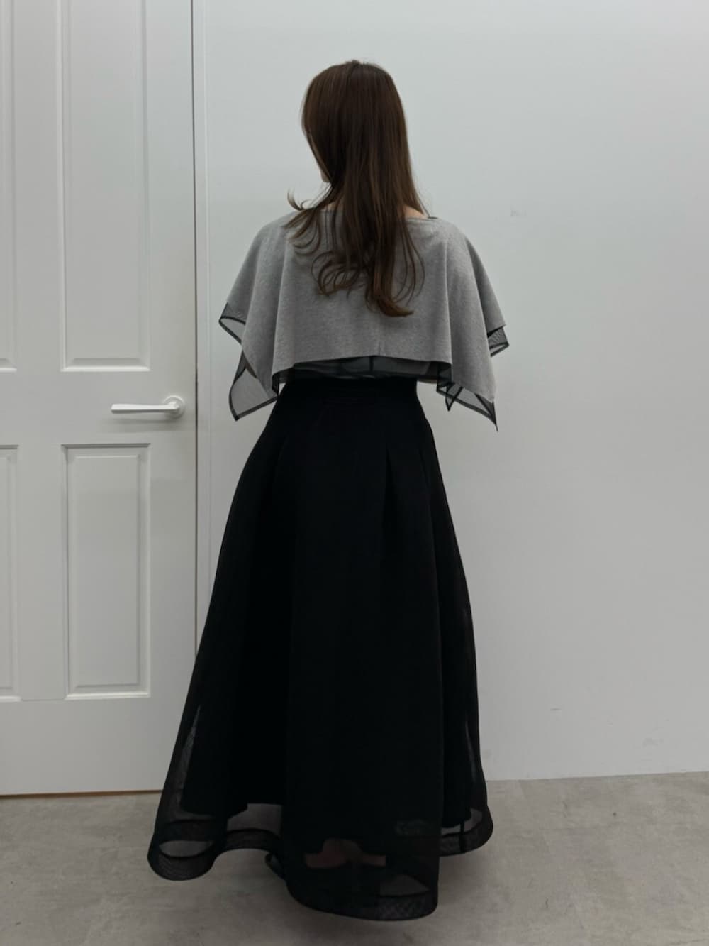ブラック系のサンダル、グレー系のTシャツ/カットソー、ブラック系のスカートを着用したレディースの春コーディネートの3枚目の写真