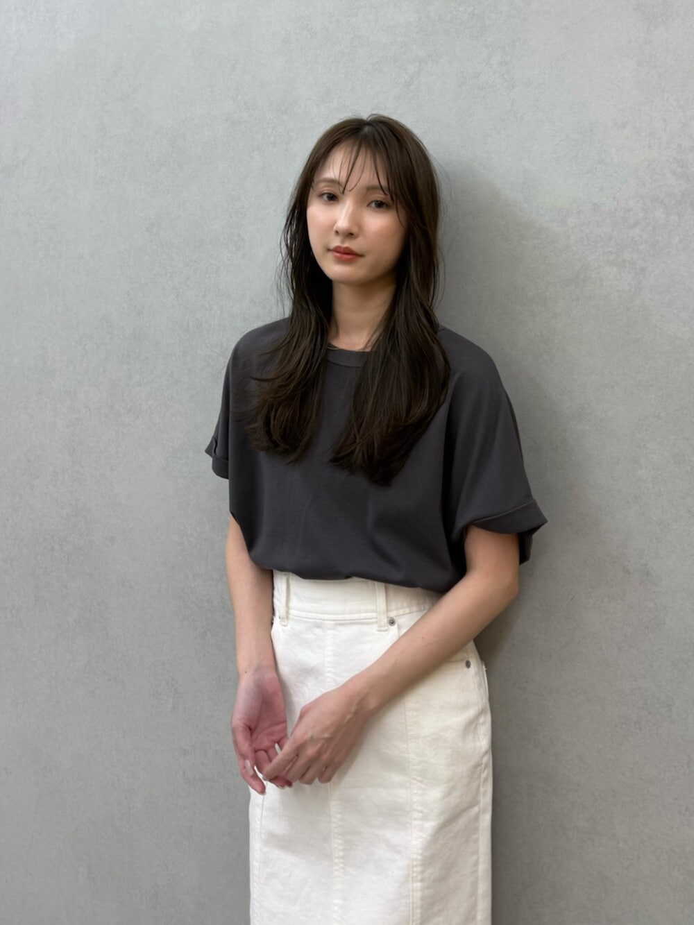 ホワイト系のスカート、ホワイト系のサンダル、グレー系のTシャツ/カットソーを着用したレディースの春コーディネートの5枚目の写真
