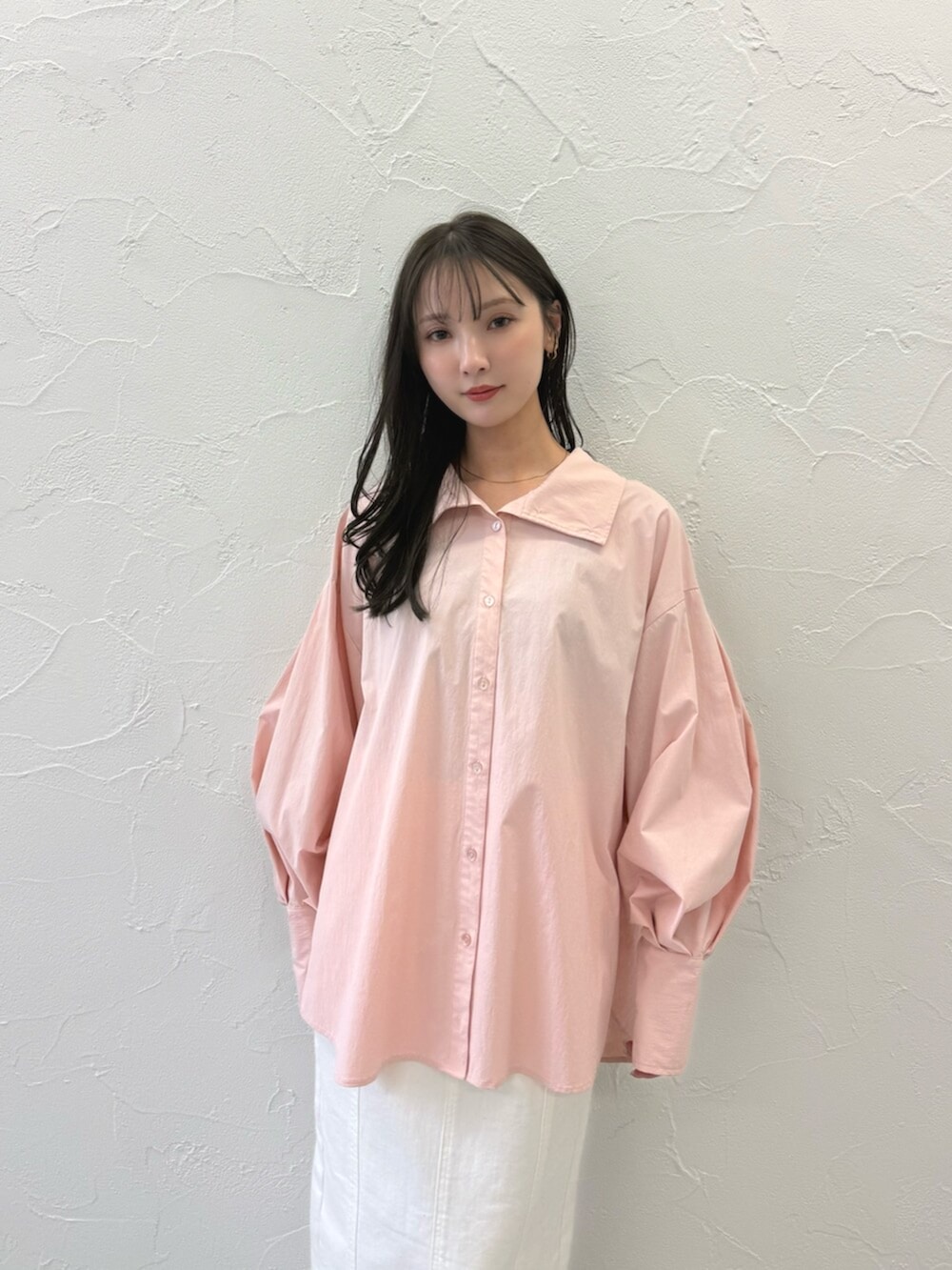 シルバー系のパンプス、ホワイト系のスカート、ピンク系のブルゾンを着用したレディースの春コーディネートの5枚目の写真