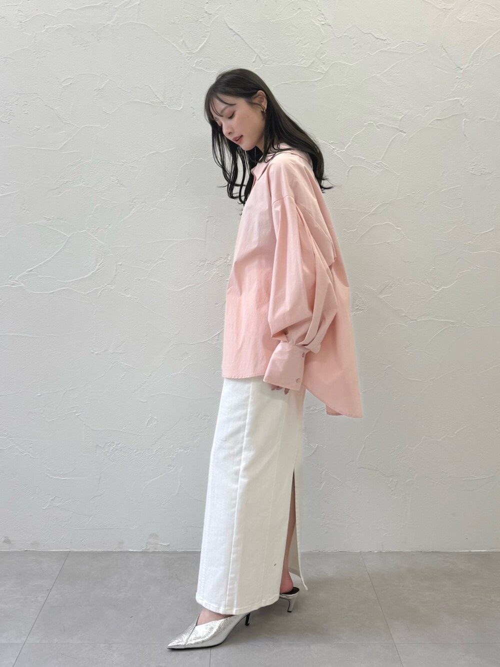 シルバー系のパンプス、ホワイト系のスカート、ピンク系のブルゾンを着用したレディースの春コーディネートの3枚目の写真