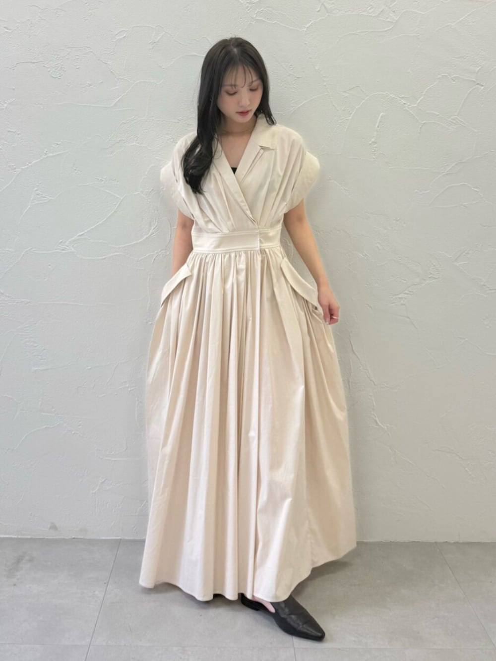 ブラック系のパンプス、ベージュ系のワンピースを着用したレディースの春コーディネートの2枚目の写真