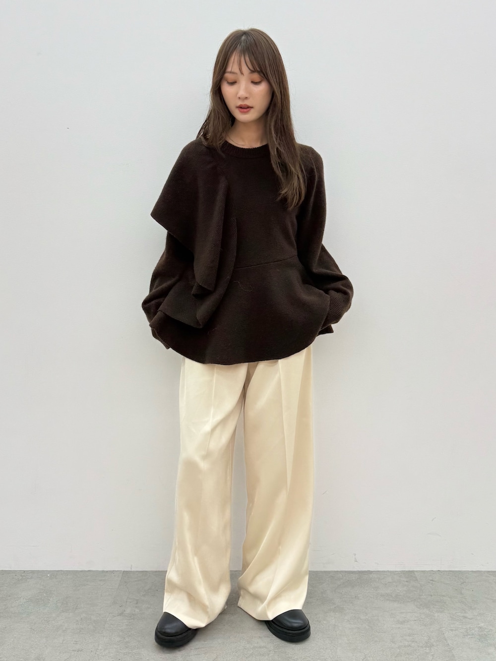 ブラウン系のニット/セーター、ホワイト系のその他パンツを着用したレディースの秋コーディネートの2枚目の写真