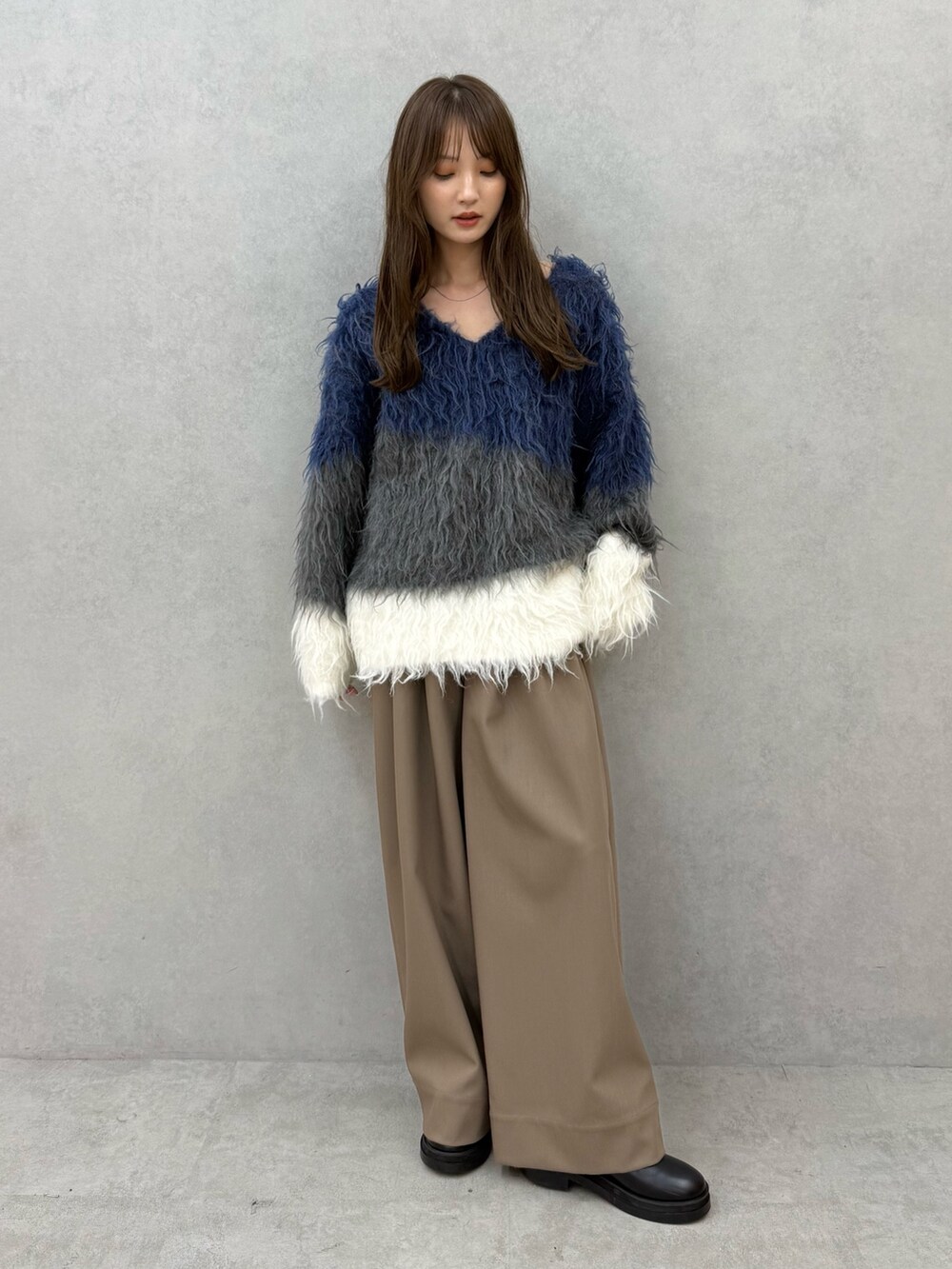 ブルー系のニット/セーター、ブラウン系のその他パンツを着用したレディースの秋コーディネートの2枚目の写真