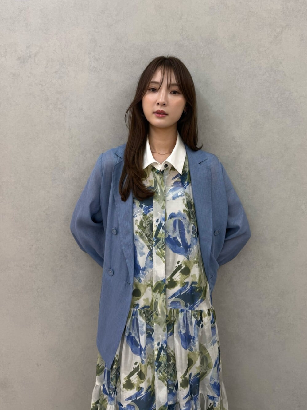 シルバー系のパンプス、ブルー系のテーラードジャケット、ブルー系のワンピースを着用したレディースの春コーディネートの5枚目の写真