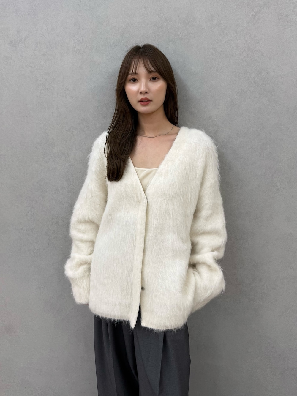 ホワイト系のカーディガン/ボレロ、グレー系のその他パンツ、ベージュ系のその他アウターを着用したレディースの秋コーディネートの7枚目の写真