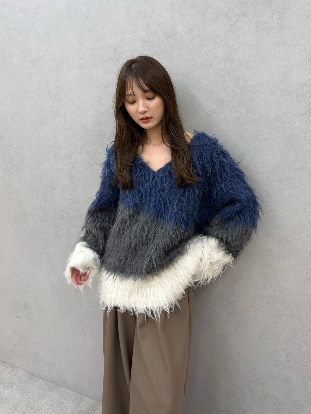 ブルー系のニット/セーター、ブラウン系のその他パンツを着用したレディースの秋コーディネートの5枚目の写真