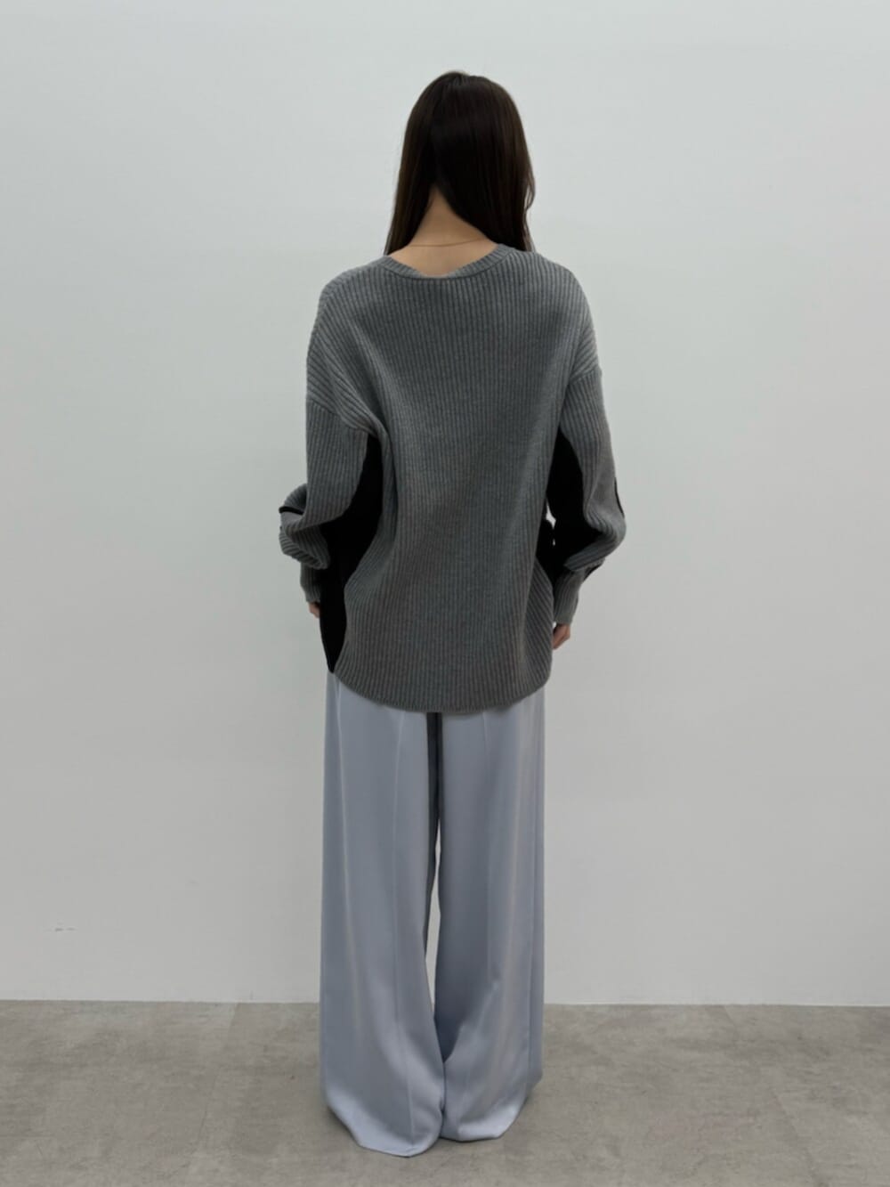 グレー系のニット/セーター、ブルー系のその他パンツ、シルバー系のパンプスを着用したレディースの秋コーディネートの3枚目の写真