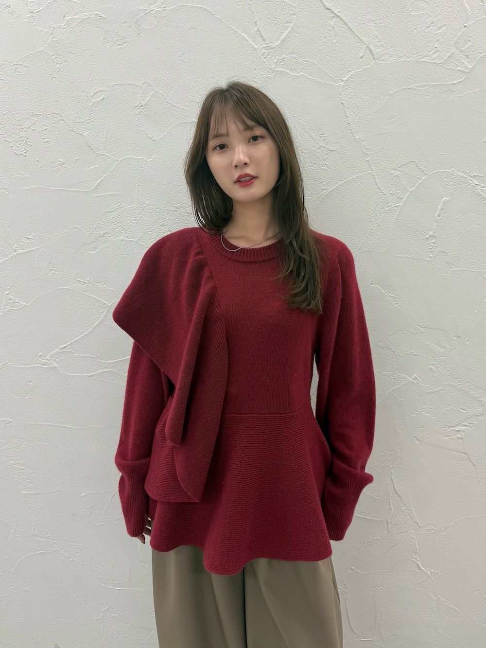 レッド系のニット/セーター、ブラウン系のその他パンツを着用したレディースの秋コーディネートの4枚目の写真