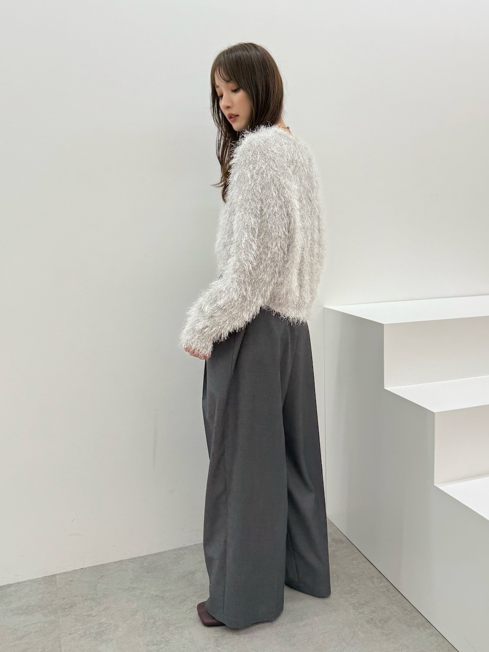 グレー系のニット/セーター、グレー系のその他パンツを着用したレディースの秋コーディネートの3枚目の写真